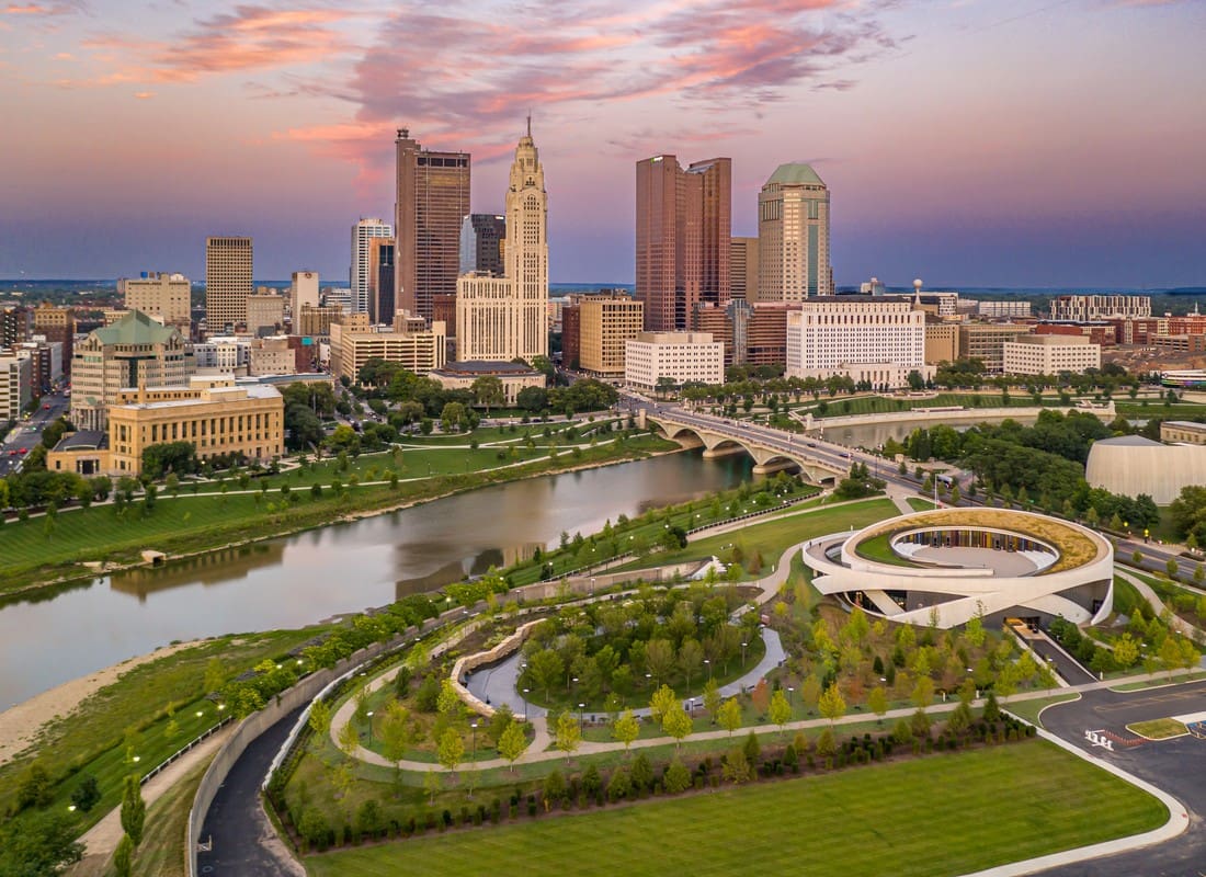 Columbus, OH - Aerial Sunset View Of Downtown Skyline With River, Bridge, And Circular Museum Building